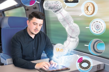 Muž pracuje ve vlaku na tabletu a animuje robotické rameno